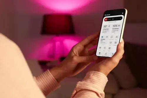 Checking home alarm status on the PhoneWatch App at night, part of summer home security