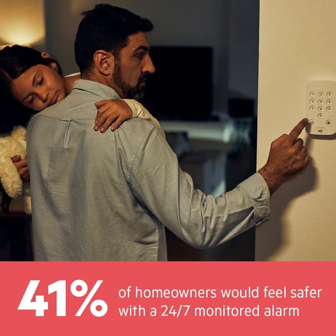 man holding his child while arming house alarm