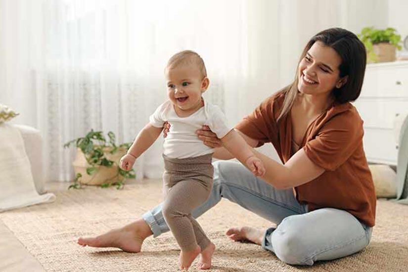 mother teaching baby to walk