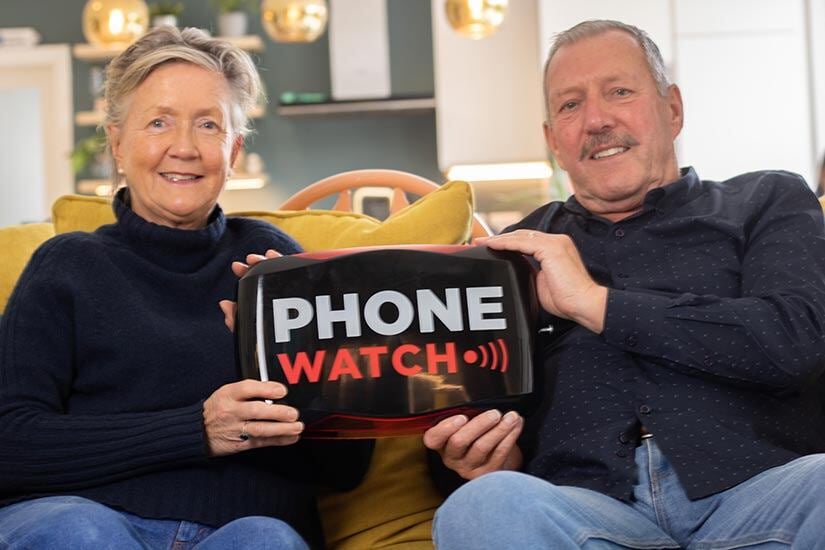 woman and man holding phonewatch alarm bellbox