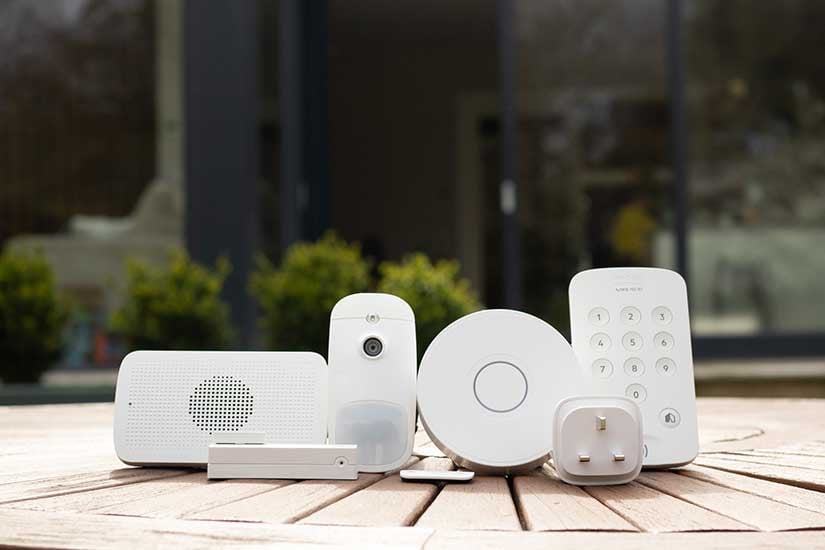 Range of home security devices displayed on a wooden table outdoors