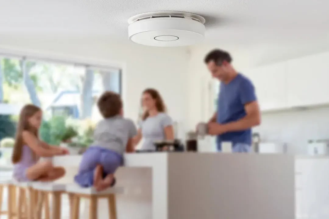 PhoneWatch smart smoke detector fitted to a kitchen ceiling above a family at home