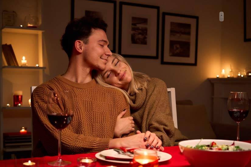 man and woman hugging at dinner table