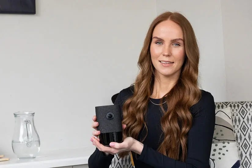 woman holding video doorbell camera in hand