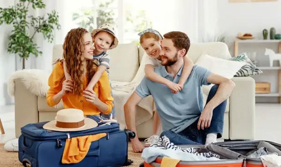 Family packing suitcases at home before a holiday, protected by a PhoneWatch monitored alarm while they are away