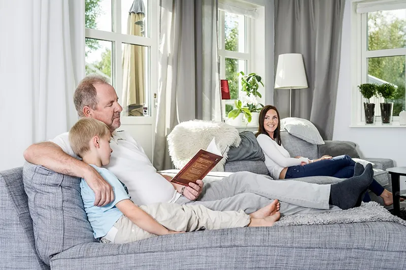 family sitting on couch reading a book